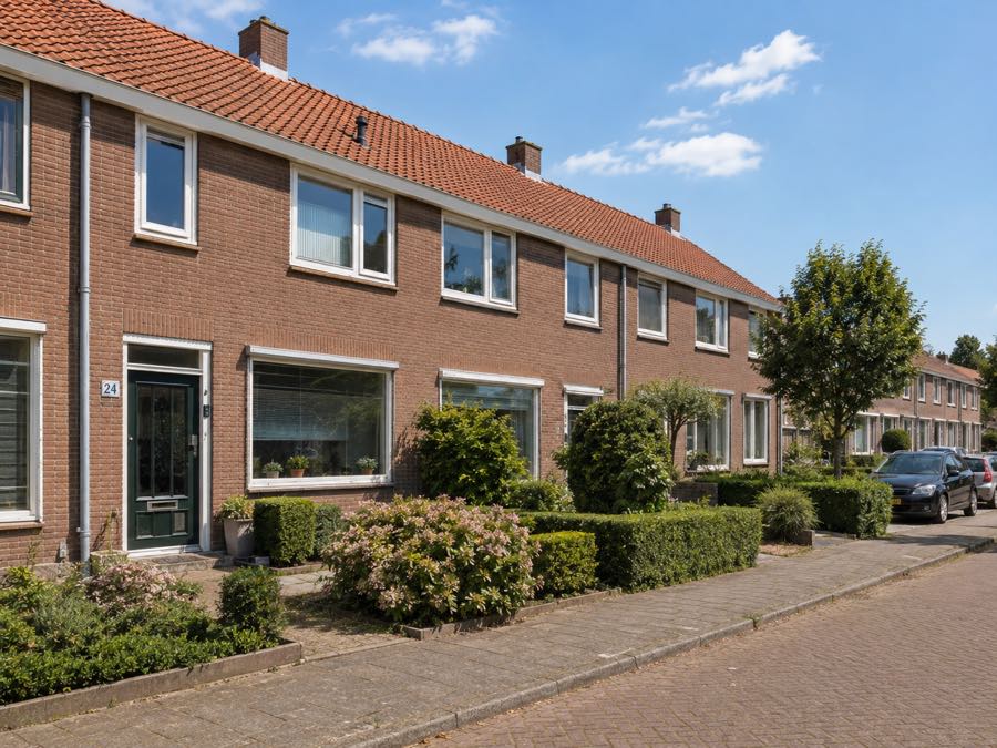 Rij Nederlandse eengezinswoningen in een groene woonstraat